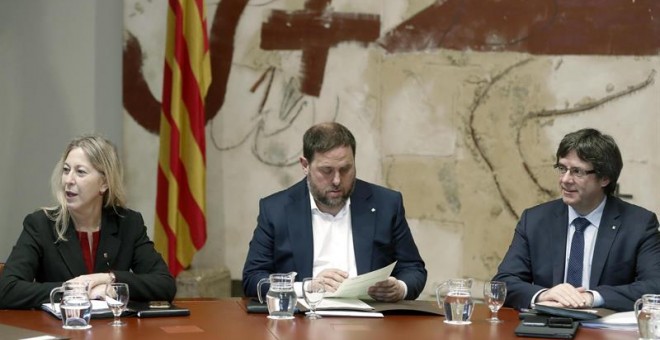 El presidente de la Generalitat, Carles Puigdemont, su vicepresidente, Oriol Junqueras (c), y la consellera de Presidencia, Neus Munté, durante la reunión del gobierno catalán, habitual de cada martes, en la semana en la que se desarrolla el juicio por el