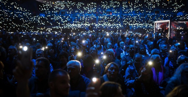 Assistents al concert en favor de l'acollida als refugiats il·luminen amb els seus mòbils