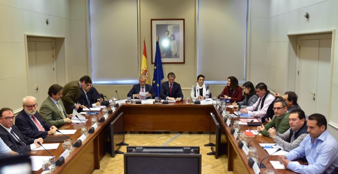 El ministro de Fomento, Iñigo de la Serna,fondo, durante la reunión celebrada en la sede del ministerio con los representantes sindicales del sector de la estiba y la patronal Anesco. EFE/Fernando Villar