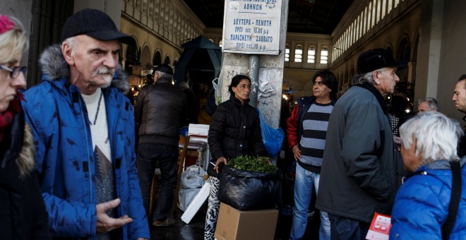 Una pareja con un puesto de venta a la puerta del principal mercado de pescado de Atenas. REUTERS/Alkis Konstantinidis