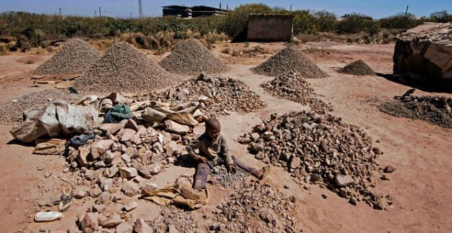 Un niño rompe rocas extraídas de una minería de cobalto en una mina de cobre y un pozo de cobalto en Lubumbashi el 23 de mayo de 2016. El precio del cobre ha caído fuertemente, afectando directamente a los trabajadores de la ciudad. JUNIOR KANNAH / AFP
