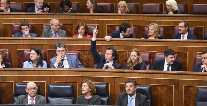 El portavoz adjunto del PP Carlos Floriano (c) marca el sentido del voto para los diputados de su grupo, durante el pleno del Congreso de los Diputados. EFE/Fernando Villar