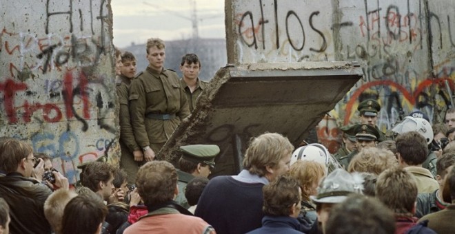 Ciudadanos de la zona de Berlín occidental se concentran frente a una de las secciones del muro derribadas el 11 de noviembre de 1989, observador por los guardias fronterizos de Alemania oriental. AFP/Gerard Malie