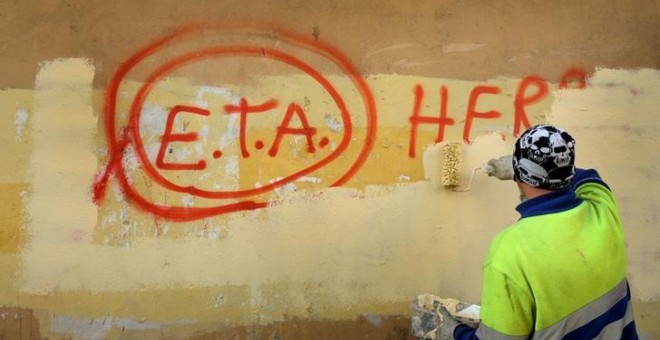 Un trabajador municipal borra un graffiti en el que se podía leer 'ETA, la gente está contigo' en el pueblo vasco de Guernica, el día después que la banda terrorista anuncaria el cese de sus actividades en 2011.REUTERS/Vincent West