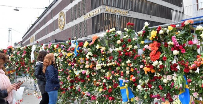 Personas han dejado flores de manera espontánea en recuerdo a los fallecidos en el atentado del pasado viernes en Suecia.- EFE