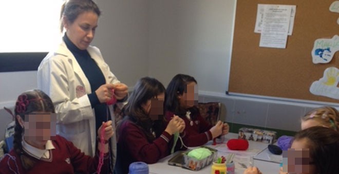 Una de las profesoras voluntarias impartiendo una clase de ganchillo en el colegio Juan Pablo II de Alcorcón. JUAN PABLO II ALCORCÓN