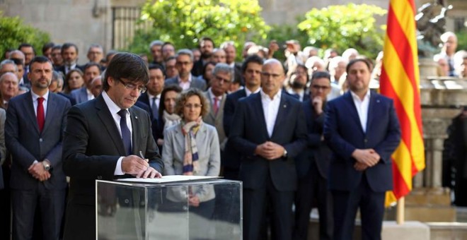 El presidente de la Generalitat, Carles Puigdemont, firma el documento tras su intervención en un acto organizado para solemnizar y escenificar el compromiso del gobierno catalán con el referéndum, que se ha celebrado en el Pati dels Tarongers del Palau d