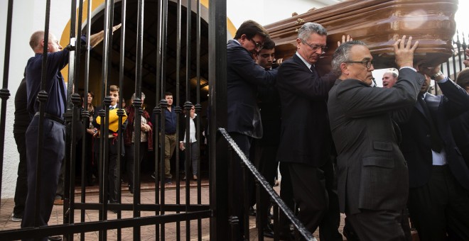 El exministro de Justicia, Alberto Ruiz Gallardón, yerno del fallecido José Utrera Molina porta junto a otros allegados el féretro del que fuera ministro en la época franquista, mientras os asistentes cantan el 'Cara al Sol', en la Iglesia de San Miguel e