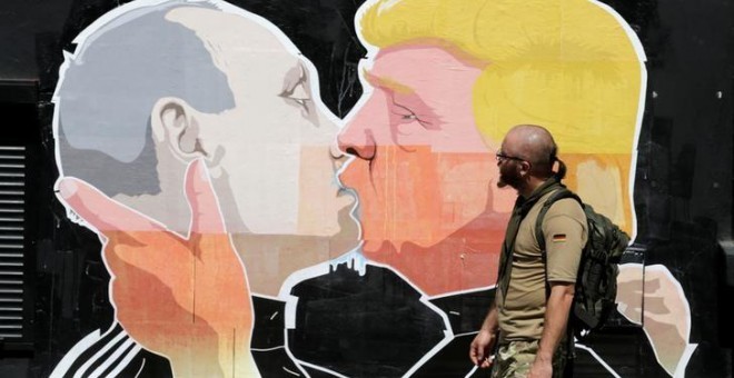 Un hombre pasa por delante de un graffiti que representa a Donald Trump (R) presidente de Estados Unidos y Vladimir Putin, presidente de Rusia, en Vilnius, Lituania. REUTERS / Ints Kalnins