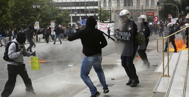 Varios activistas se enfrentan a la policía antidisturbios mientras participan en una manifestación durante la huelga general de 24 horas en Atenas (Grecia).EFE/Alexandros Vlachos