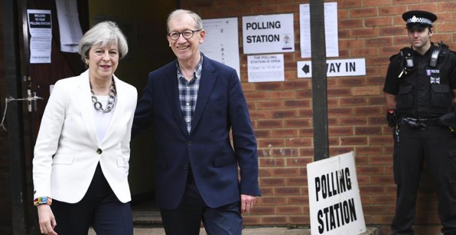La primera ministra británica, Theresa May, y su marido posan antes de votar en un colegio electoral en Sonning. - EFE