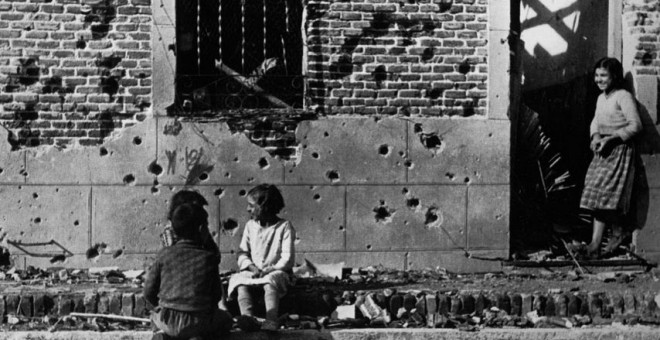 Robert Capa  Los niños juegan ajenos al horror de la guerra ante la fachada destrozada  por la metralla del número 10 de la calle Peironcely, November-December  1936  ©International Center of Photography/Magnum Photos