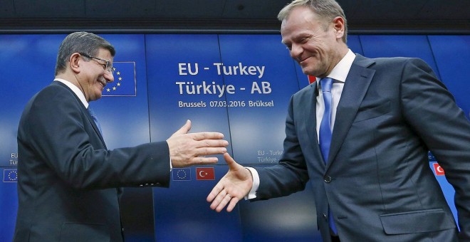 El primer ministro turco, Ahmet Davutoglu, estrecha la mano del presidente del Consejo Europeo, Donald Tusk.