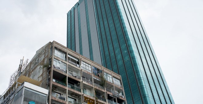 Un viejo edificio hace frente a un rascacielos moderno en el distrito céntrico 1 en Ho Chi Minh. Los dos edificios están en la primera y única calle peatonal de Vietnam. La mitad de los pisos en el edificio antiguo han sido convertidos en cafeterías.