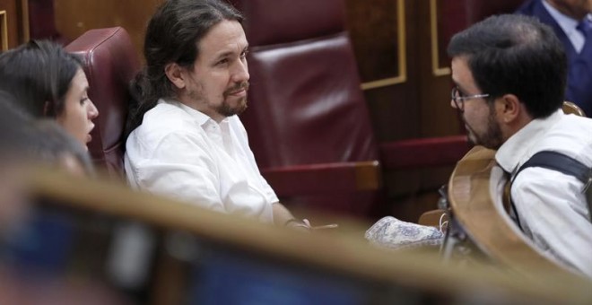 El secretario general de Podemos, Pablo Iglesias conversa con el coordinador general de IU, Alberto Garzón, durante el pleno del Congreso que se celebró el 20 de junio. | CHEMA MOYA (EFE)