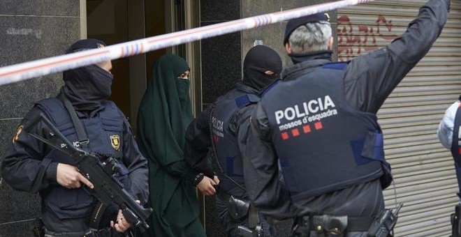 Agentes de los Mossos d'Esquadra detienen a una joven en el marco de una operación contra el terrorismo yihadista. ALEJANDRO GARCIA (EFE)