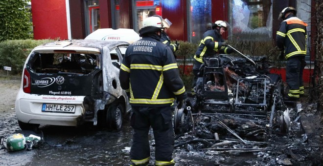 Los Bomberos de Hamburgo apagan las llamas de un coche calcinado, /REUTERS
