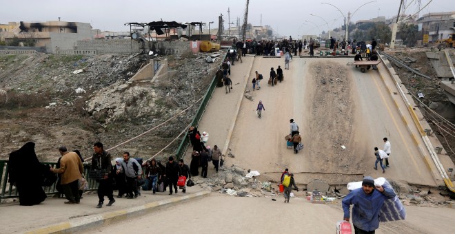 Personas desplazadas que huyen de los militantes del Estado Islámico cruzan el puente del barrio de Al-Muthanna en Mosul REUTERS/Ahmed Saad/File photo