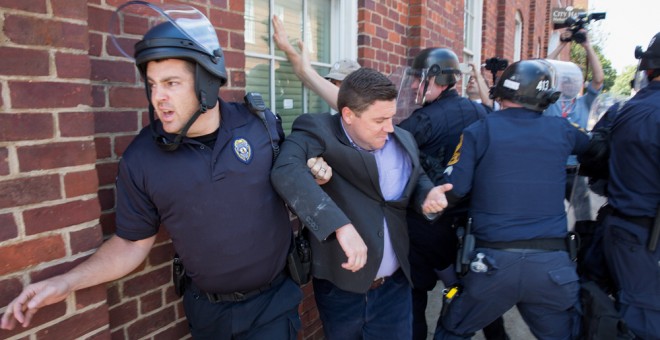 La policía escolta a Jason Kessler, organizador del mitin del grupo ultra 'Unite the Right'', después de una rueda de prensa en el Ayuntamiento de Charlottesville, Virginia. EFE / EPA / TASOS KATOPODIS
