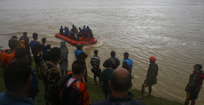 Grupos de personas afectadas por las inundaciones en Nepal esperan a ser rescatados en botes neumáticos. EFE/EPA/NARENDRA SHRESTHA