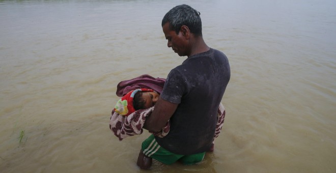 Un nepalí traslada el cadáver de un niño muerto por las inundaciones por el país. EFE / EPA / NARENDRA SHRESTHA