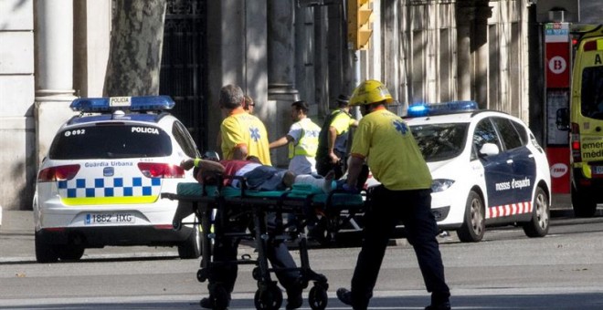 Los servicios de emergencia trasladan a una de las personas afectadas por el atropello de una furgoneta esta tarde por las Ramblas de Barcelona, en un atropello masivo. Los Mossos d'Esquadra y los equipos de emergencias sanitarias han desplegado un amplio