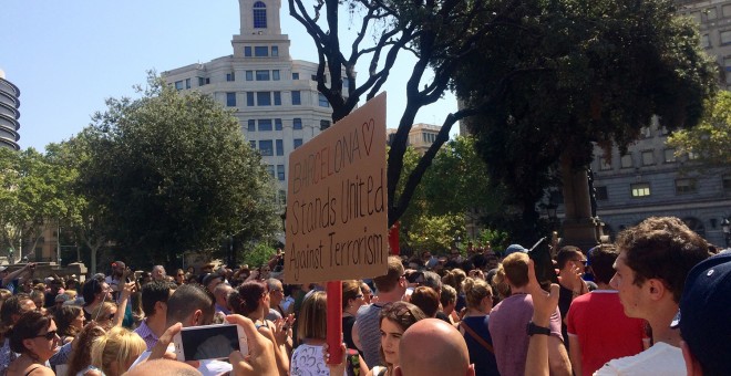 Una noia amb una pancarta a l'acte de solidaritat amb les víctimes a plaça Catalunya. FOTO: Elena Parreño