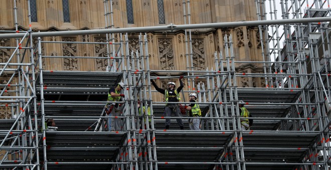 Unos trabajadores instalan los andamios que van a cubrir la Elizabeth Tower del Parlamento británico, donde está el reloj 'Big Ben', que va a permanecder parado cuatro años por obras de restauración.. REUTERS/Peter Nicholls