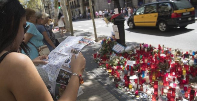 Una joven consulta un plano ante una de las ofrendas en las Ramblas cuatro días después de los atentados. EFE/Marta Pérez