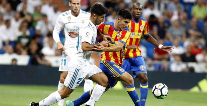 El delantero del Real Madrid Marco Asensio lucha el balón con Carlos Soler, del Valencia CF. - EFE