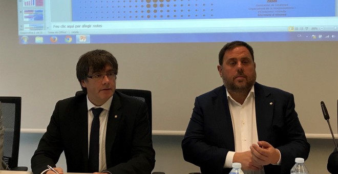 El president del Govern, Carles Puigdemont, y el vicepresidente, Oriol Junqueras, durante la rueda de prensa para presentar el despliegue de la Agencia Tributaria de Cataluña este lunes. EUROPA PRESS