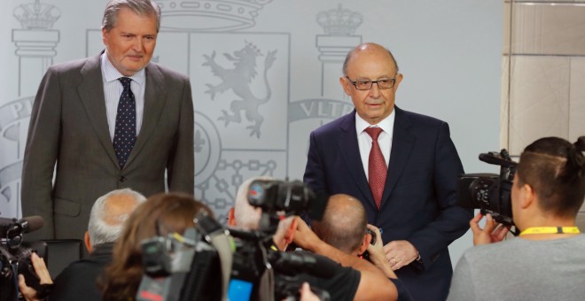 El portavoz del Gobierno y ministro de Educación, Cultura y Deporte, Íñigo Méndez de Vigo (i), y el ministro de Hacienda, Cristóbal Montoro, durante la rueda de prensa posterior a la reunión del Consejo de Ministros celebrada en el Complejo de La Moncloa.