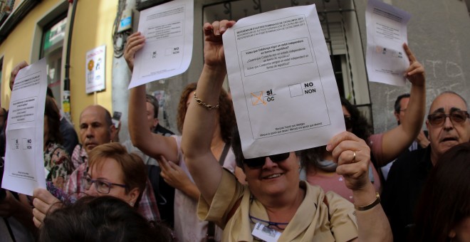 Varios manifestantes en el acto de 'Madrileños por el derecho a decidir' se concentran a las puertas del Teatro del Barrio en Malasaña sujetando papeletas del referéndum del 1 de octubre. REUTERS/Sergio Pérez