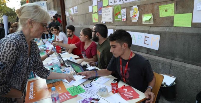 Estudiantes de la Universitat Central en las mesas informativas que han habilitado para orientar a la población sobre el referéndum. EFE/Toni Albir