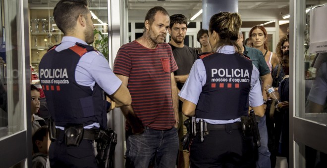 Los Mossos acceden a Escola Auró para levantar acta de las actividades que realizan los colegios y para advertir de que tienen que estar cerrados antes de las 6:00 h. de la mañana del domingo. EFE/Biel Aliño.