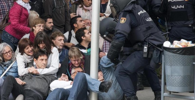 La Policía Nacional que ha requisado las urnas en el ambulatorio del barrio leridano de Cappont forcejea con unos ciudadanos . Las sedes de los centros de votación del 1-O en la ciudad de Lleida están viviendo una mañana protagonizada por la incertidumbre