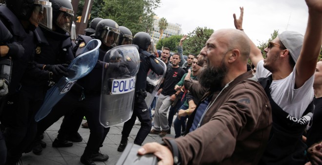 Agentes de la Policía Nacional fretne a las personas concentradas en un colegio electoral en Tarragona, durante la jornada del referéndum del 1-O. REUTERS/David Gonzalez