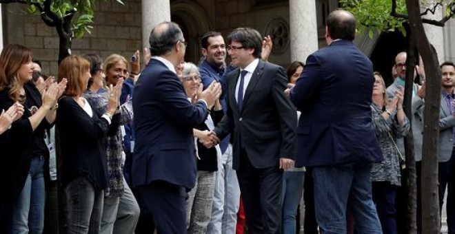 l presidente catalán, Carles Puigdemont (c), junto al vicepresidente Oriol Junqueras (d), y el conseller de Presidencia, Jordi Turull (i), saluda a los trabajadores de la Generalitat que les han recibido con aplausos a su llegada a la reunión extraordinar