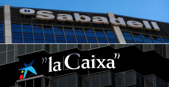 Los logos del Banco Sabadel y de Caixabank en sus sedes en Barcelona. REUTERS