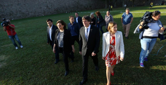 El presidente de la Generalitat, Carles Puigdemont, con la alcaldesa de Barcelona, Ada Colau, y la presidenta del Parlament, Carme Forcaell, tras el acto de homenaje a Luís Companys,en el lugar donde fue fusilado. REUTERS/Ivan Alvarado