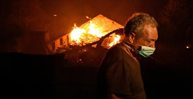 Un hombre entre las llamas en un incendio forestal declarado en Adica, Tondela (Portugal). / EFE