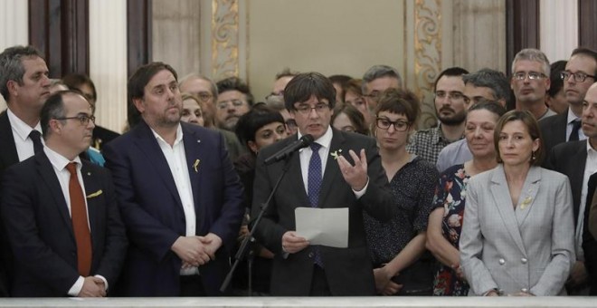 El presidente de la Generalitat, Carles Puigdemont (c) junto al vicepresidente del Govern y conseller de Economía, Oriol Junqueras y la presidenta del Parlament, Carme Forcadell, realiza una declaración en las escalinatas del Parlamen del Parlament tras a