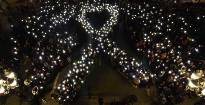 Els manifestants dibuixen amb els seus mòbils el signe de solidaritat amb el presos, un llaç gegant a la plaça de Sant Jaume