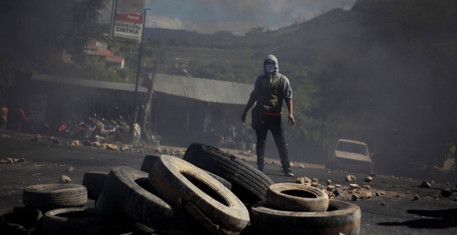 Uno de los manifestantes contra el presunto fraude electoral en Honduras tras una barricada en las calles de Tegucigalpa.REUTERS/Jorge Cabrera