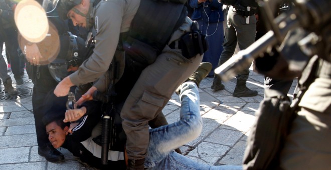 Un policía israelí detiene a un joven palestino cerca de la Puerta de Damasco, en Jerusalén, tras la oración del viernes. REUTERS/Ronen Zvulun