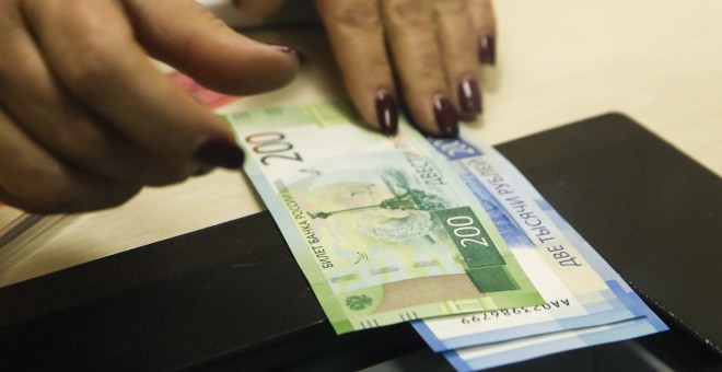 Una cajera con billetes de 200 y de 2.000 rublos, en un banco de Moscu. REUTERS/Maxim Shemetov