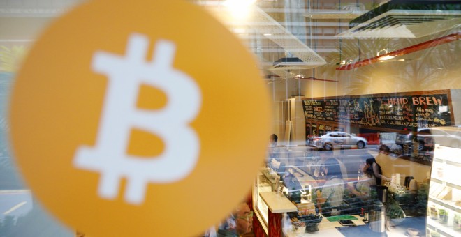 El logo de Bitcoin en una ventana del cibercafé 'Ducatus', de Singapur, el primer en aceptar las criptomonedas. REUTERS/Edgar Su