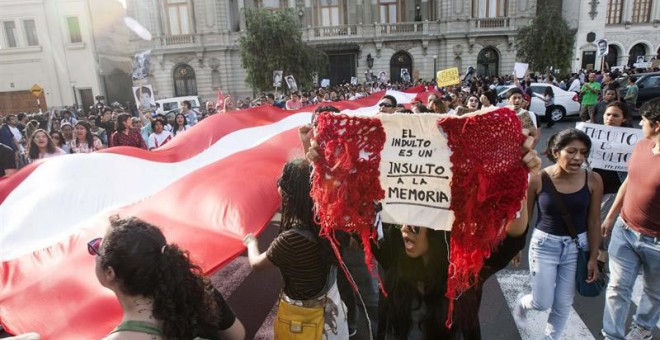 Una manifestante sostiene una bandera de Perú con un mensaje contra el indulto otorgado al expresidente Alberto Fujimori durante la protesta en Lima. | EDUARDO CAVERO (EFE)