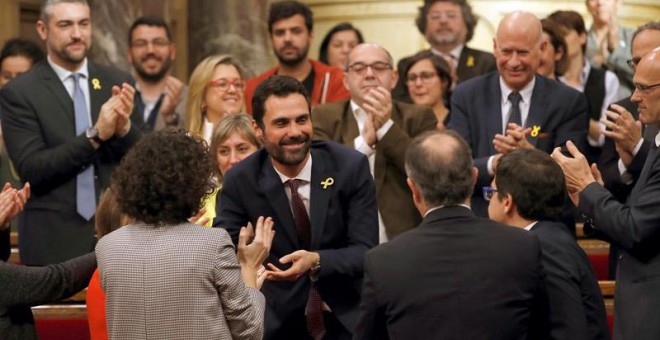 El nuevo presidente del Parlament, Roger Torrent (centro), recibe la felicitación de sus compañeros tras ser elegido durante la sesión constitutiva del Parlamento catalán de la XII legislatura. | EFE