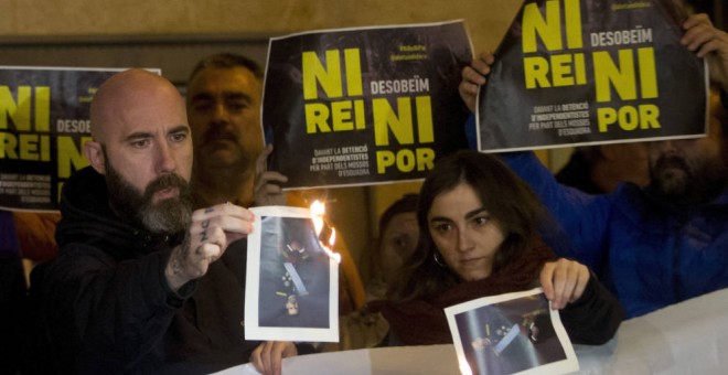 El concejal de la CUP en el Ayuntamiento de Barcelona Josep Garganté (i) quema una foto del Rey (Efe).